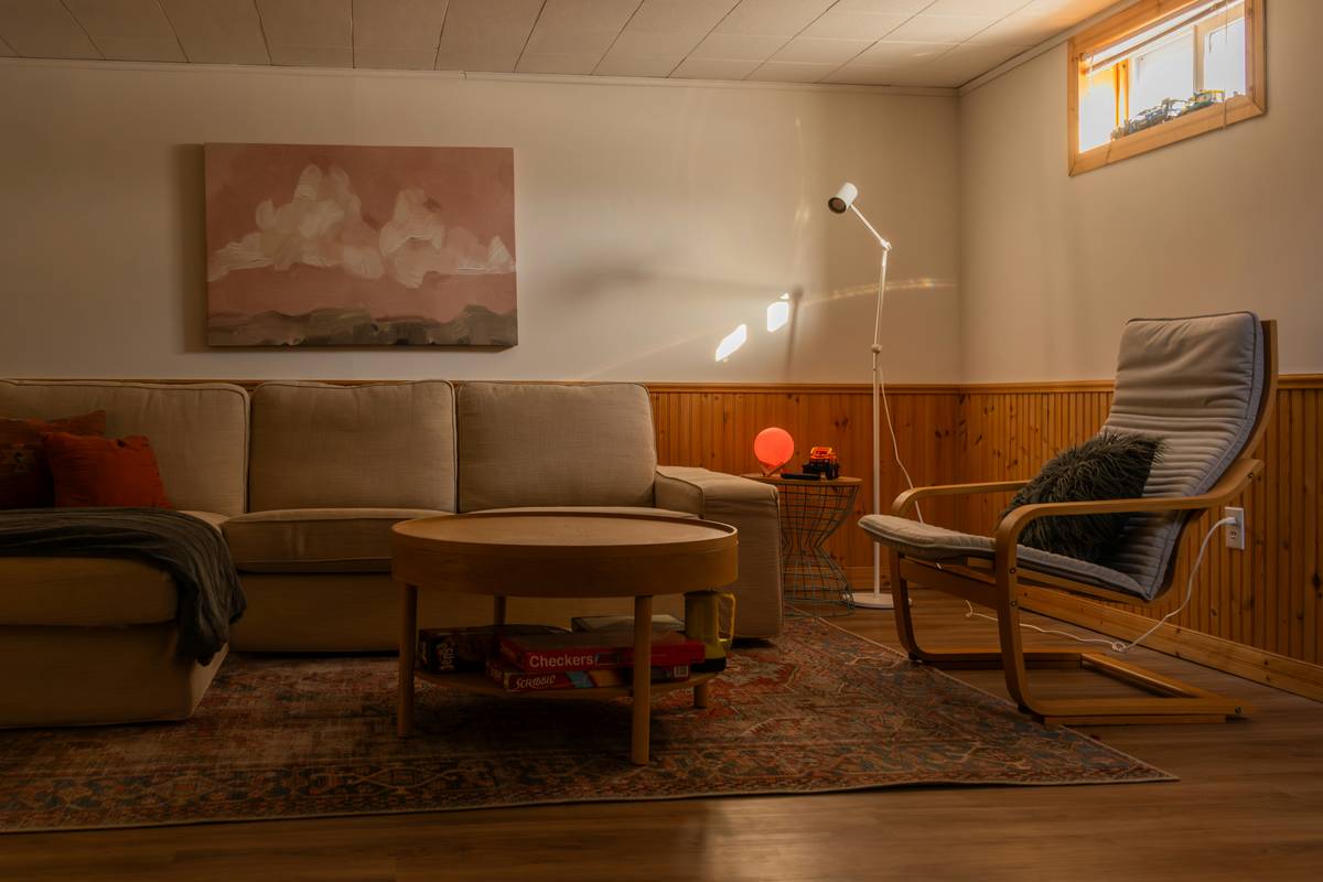 A softly lit bedroom featuring layered warm-toned sconces, a dimmed table lamp, and indirect cove lighting—showcasing light for mood therapy in practice